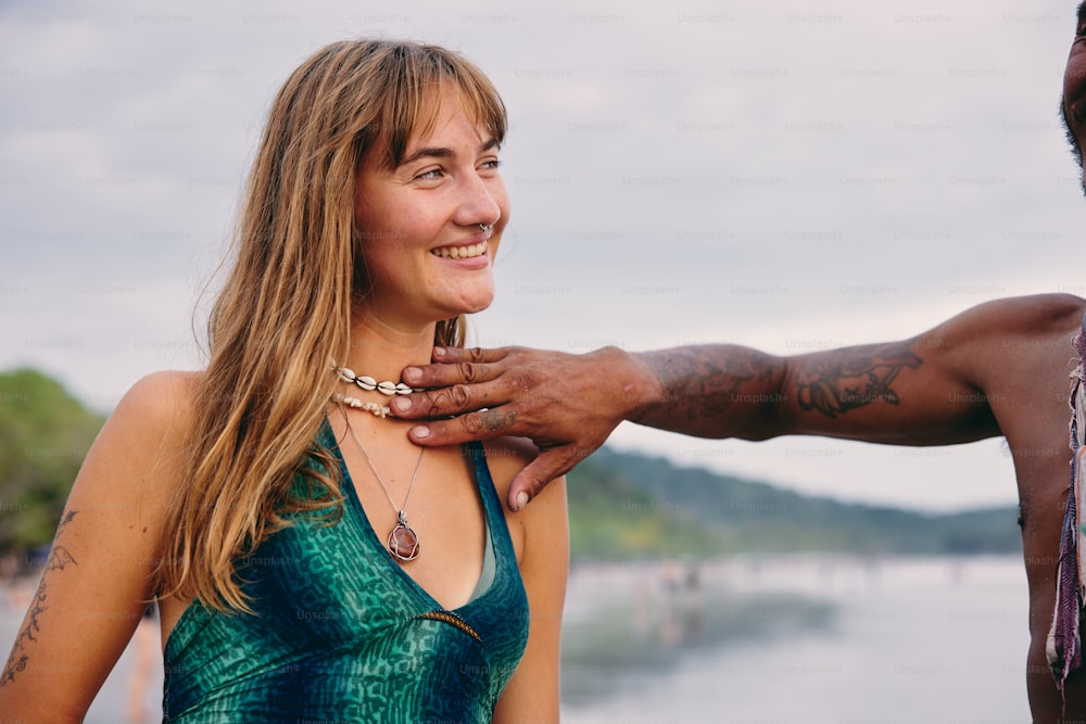 a man holding a woman's hand near a body of water