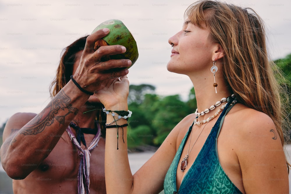 a man and a woman are holding a coconut