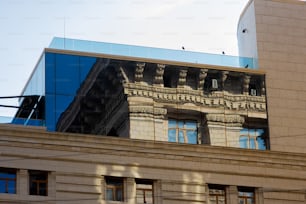 a building with a reflection of another building in the windows