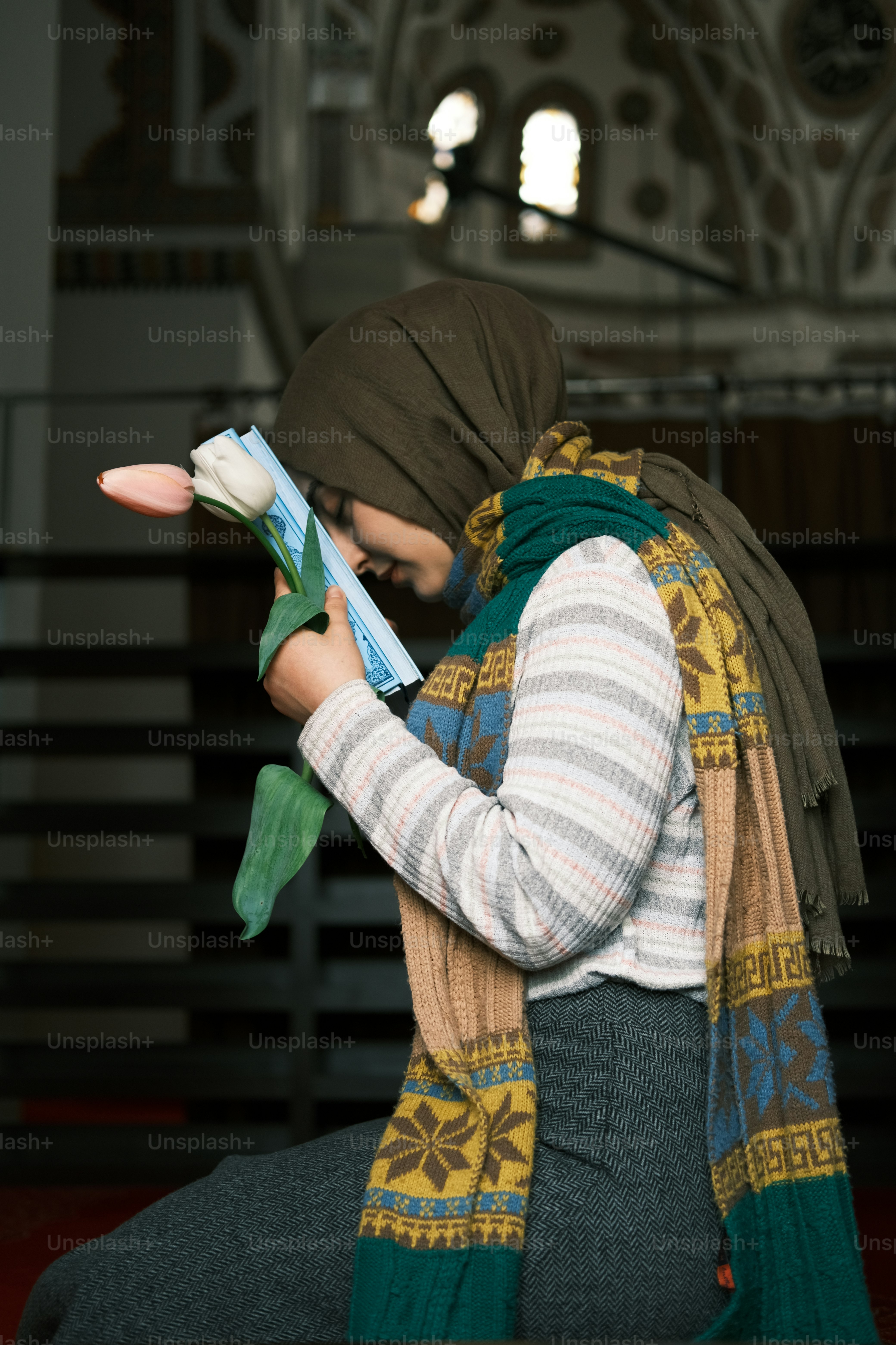 a woman in a headscarf reading a book