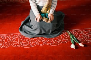 a small child sitting on a red rug