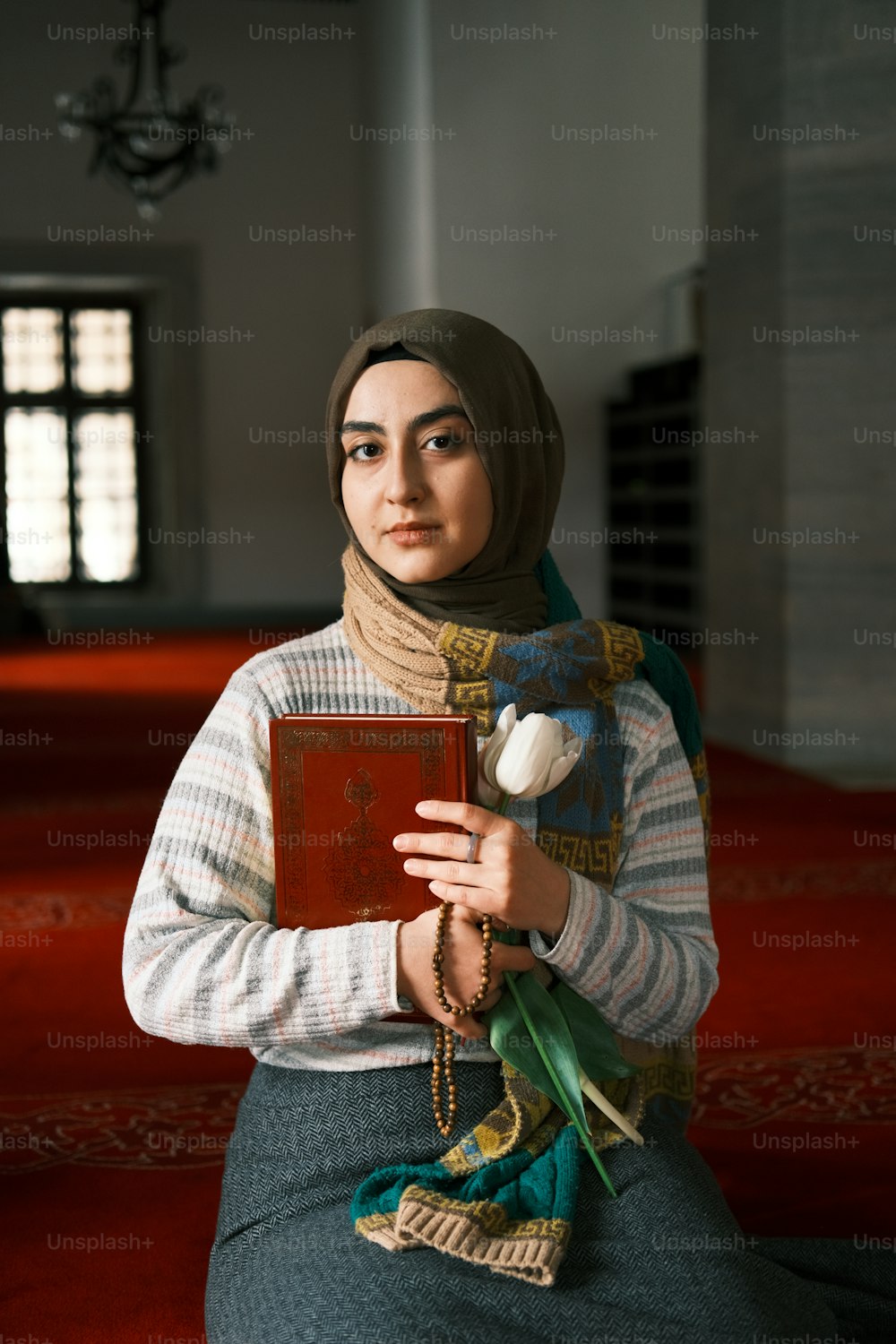 a woman in a headscarf holding a book