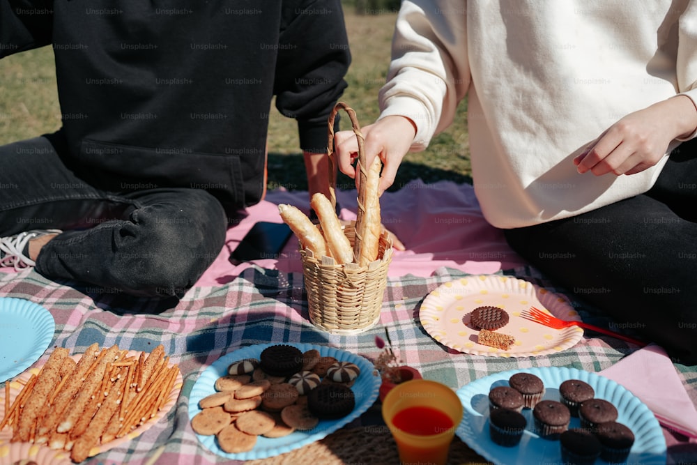 Dos personas sentadas en una mesa de picnic con bocadillos