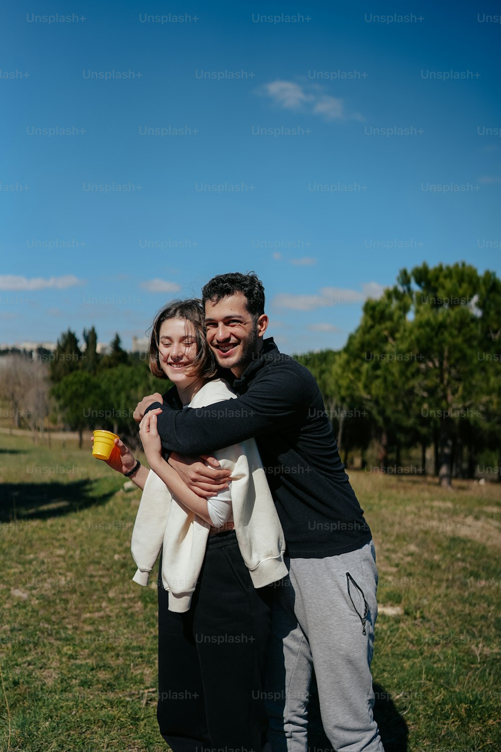 a man and a woman hugging in a field