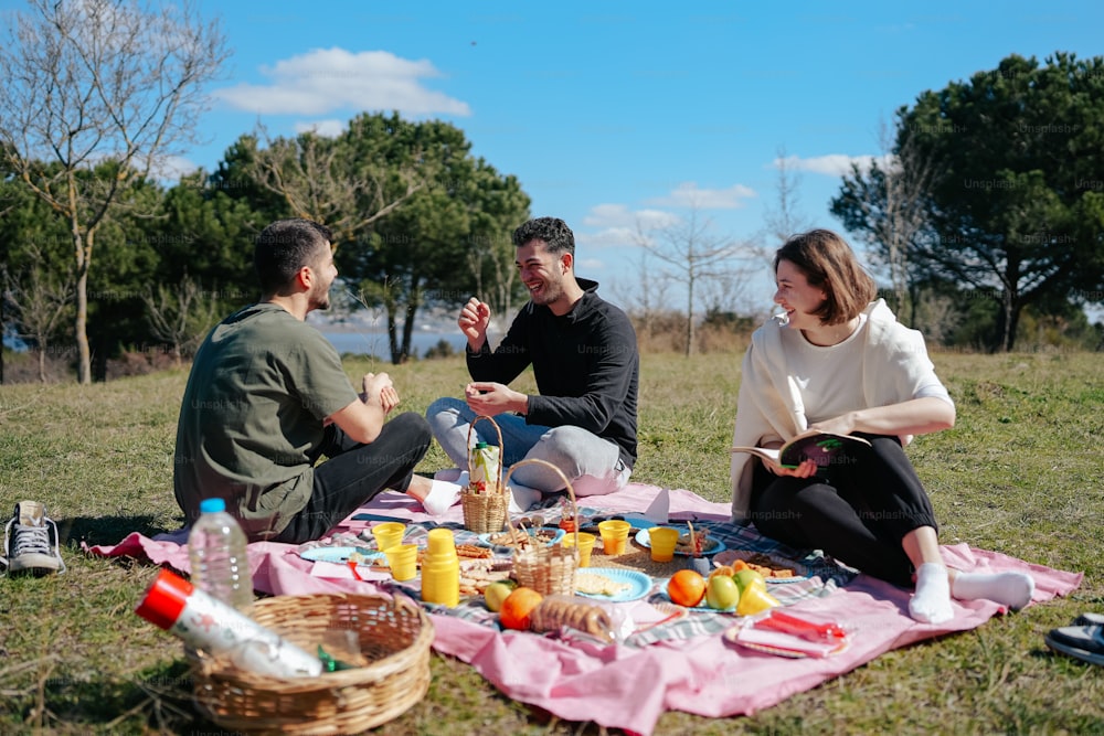 a group of people sitting on top of a grass covered field