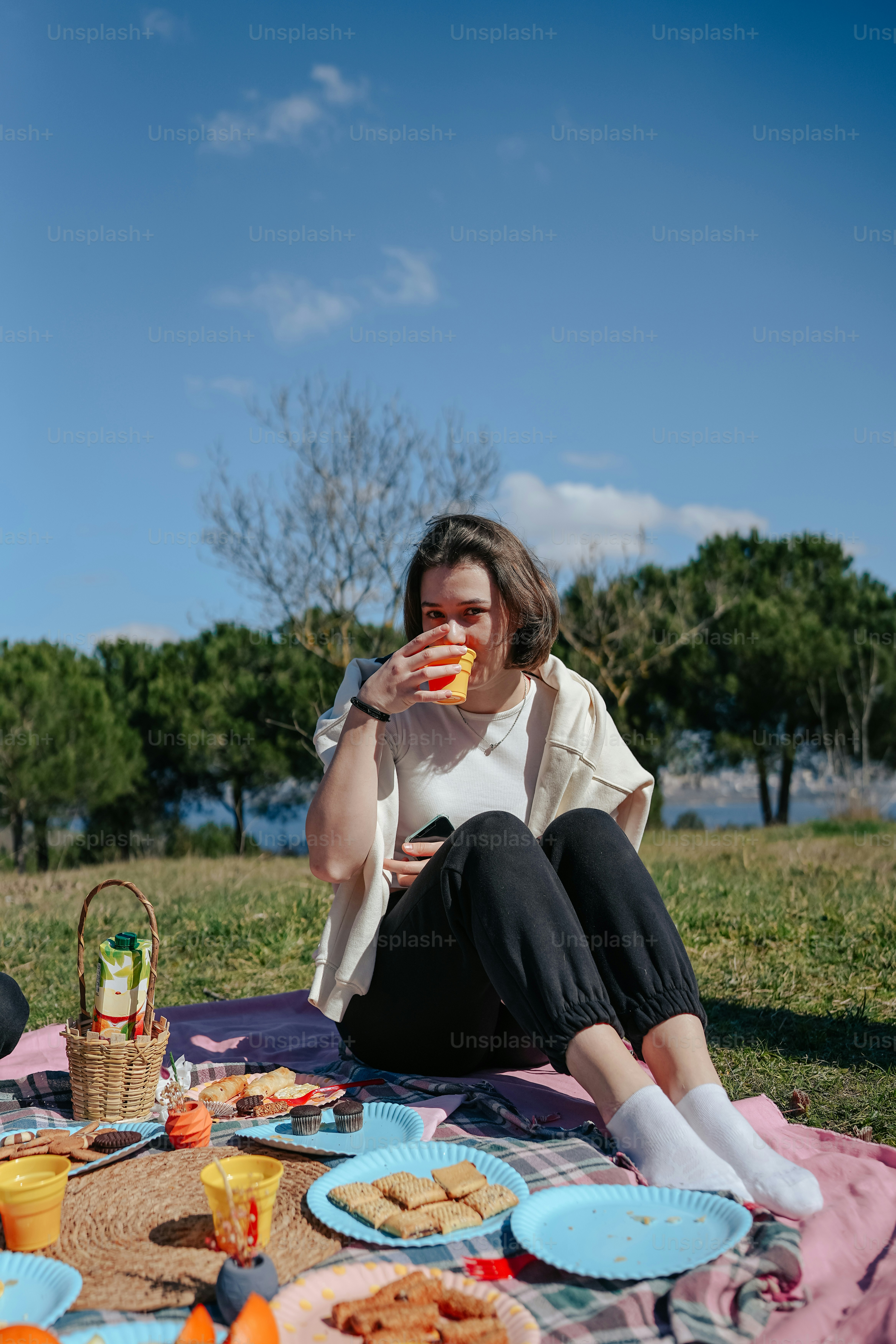 a woman sitting on a blanket eating food