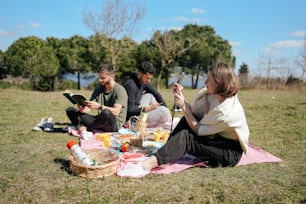 a group of people sitting on top of a grass covered field