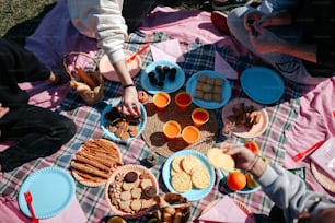 um grupo de pessoas sentadas ao redor de uma mesa com pratos de comida