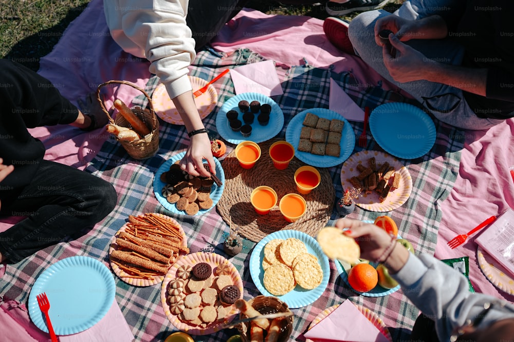 un groupe de personnes assises autour d’une table avec des assiettes de nourriture