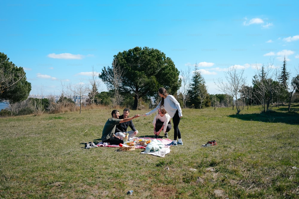 um grupo de pessoas sentadas em cima de um campo coberto de grama