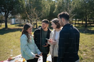 Un grupo de personas de pie alrededor de una mesa de picnic