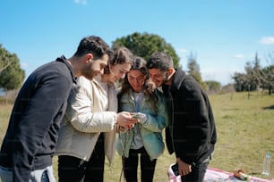 a group of people looking at a cell phone
