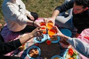 a group of people sitting around a table filled with food