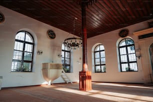 a room with three windows and a clock on the wall