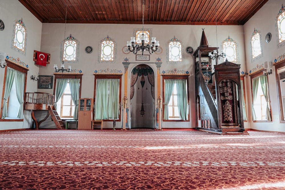 a large room with a red carpet and many windows