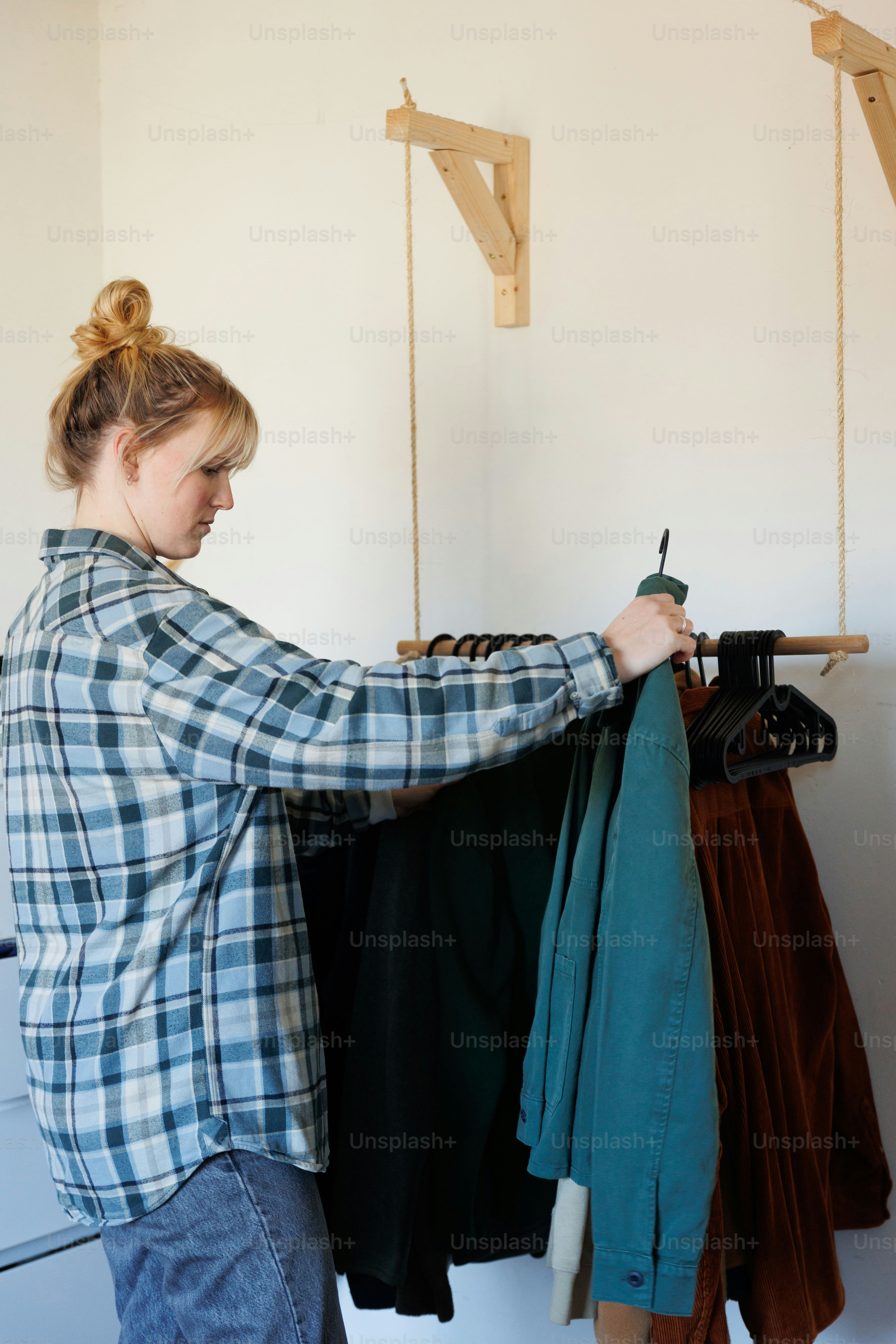 A woman standing in front of a rack of clothes photo – Decluttering ...