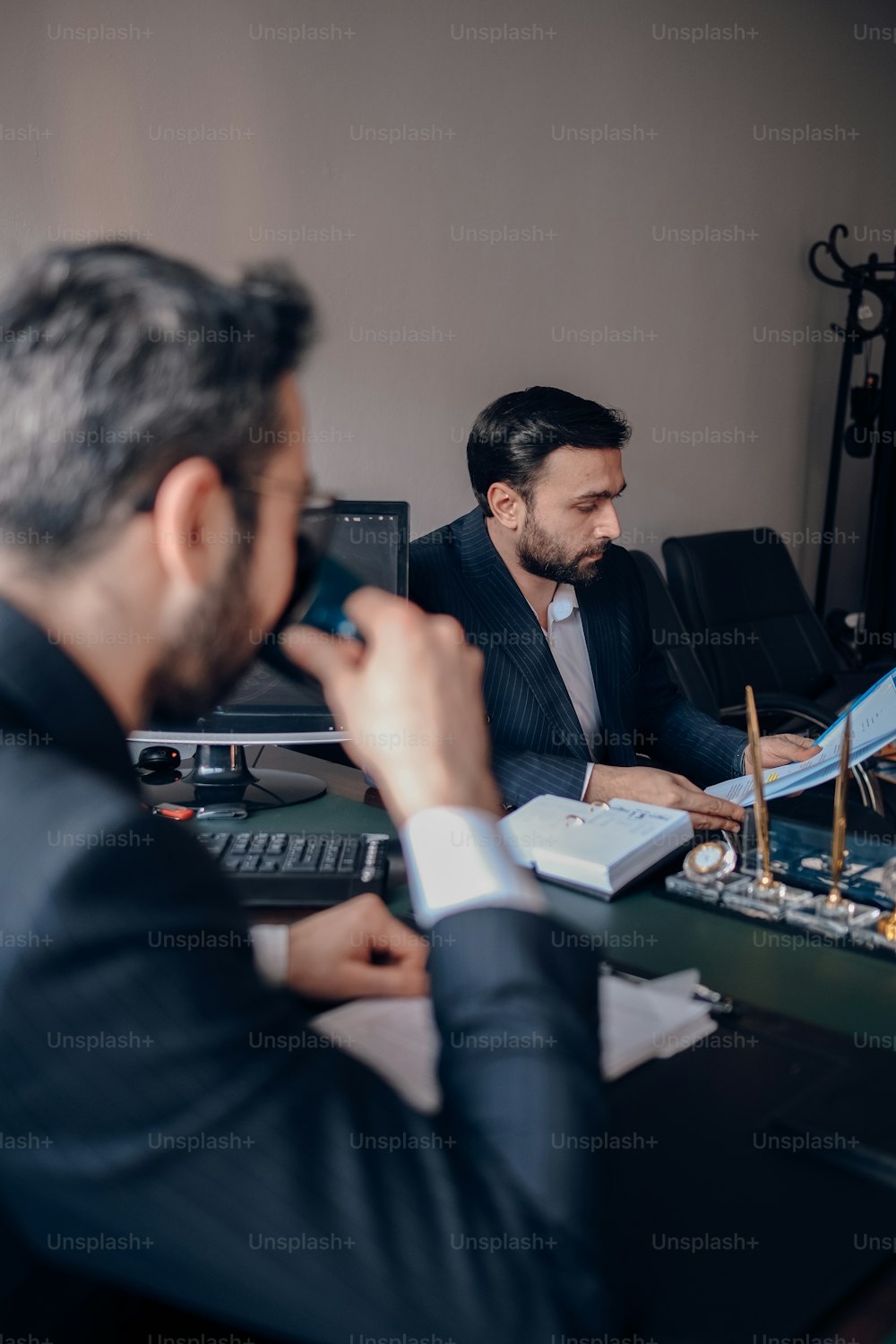 two men sitting at a desk working on a project