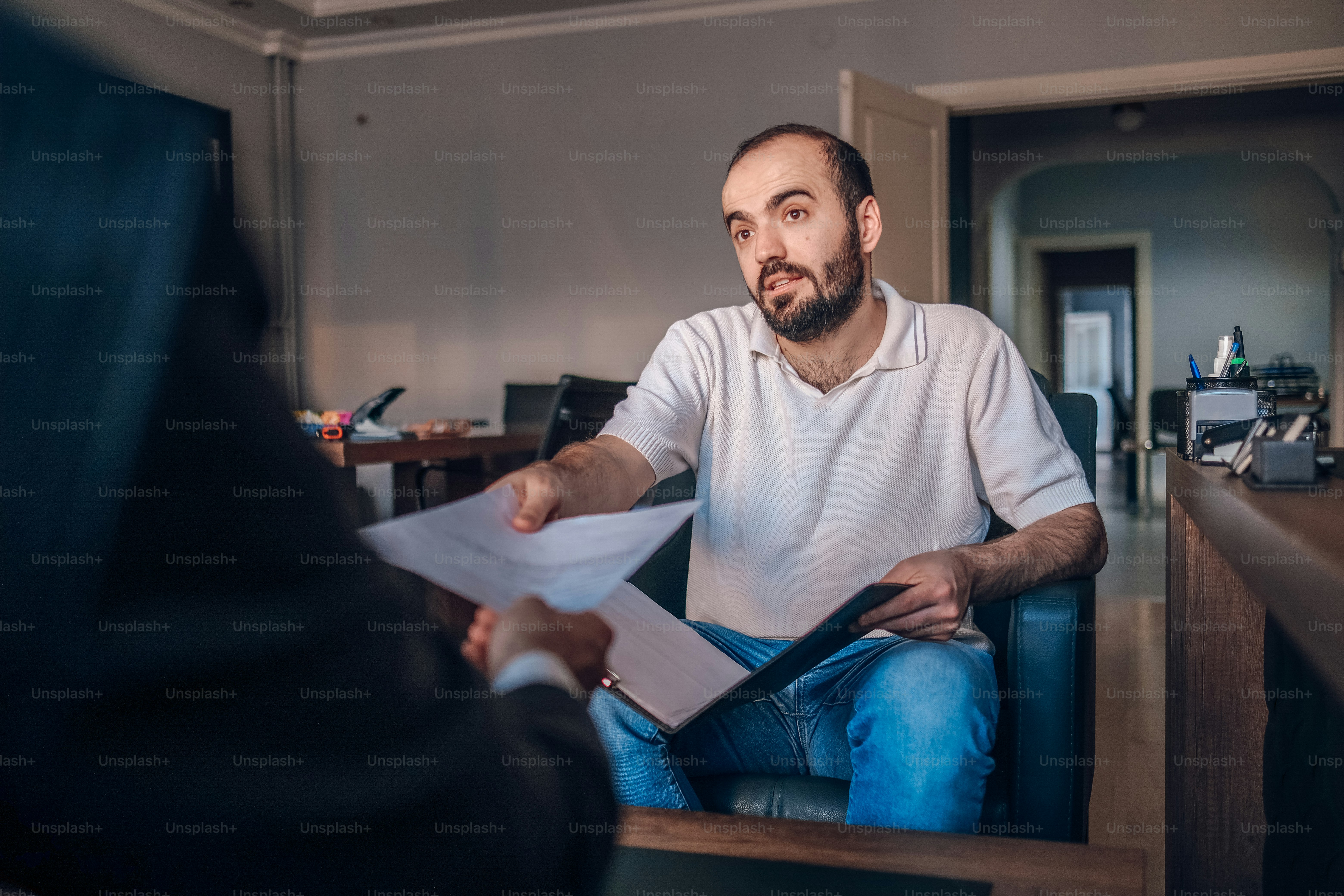 a man sitting in a chair holding a piece of paper