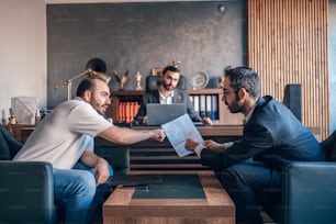 two men sitting on couches in a living room