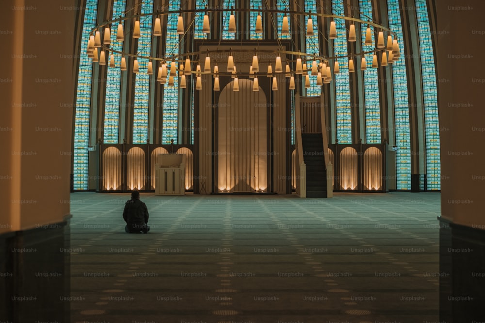 a person sitting in a large room with a chandelier