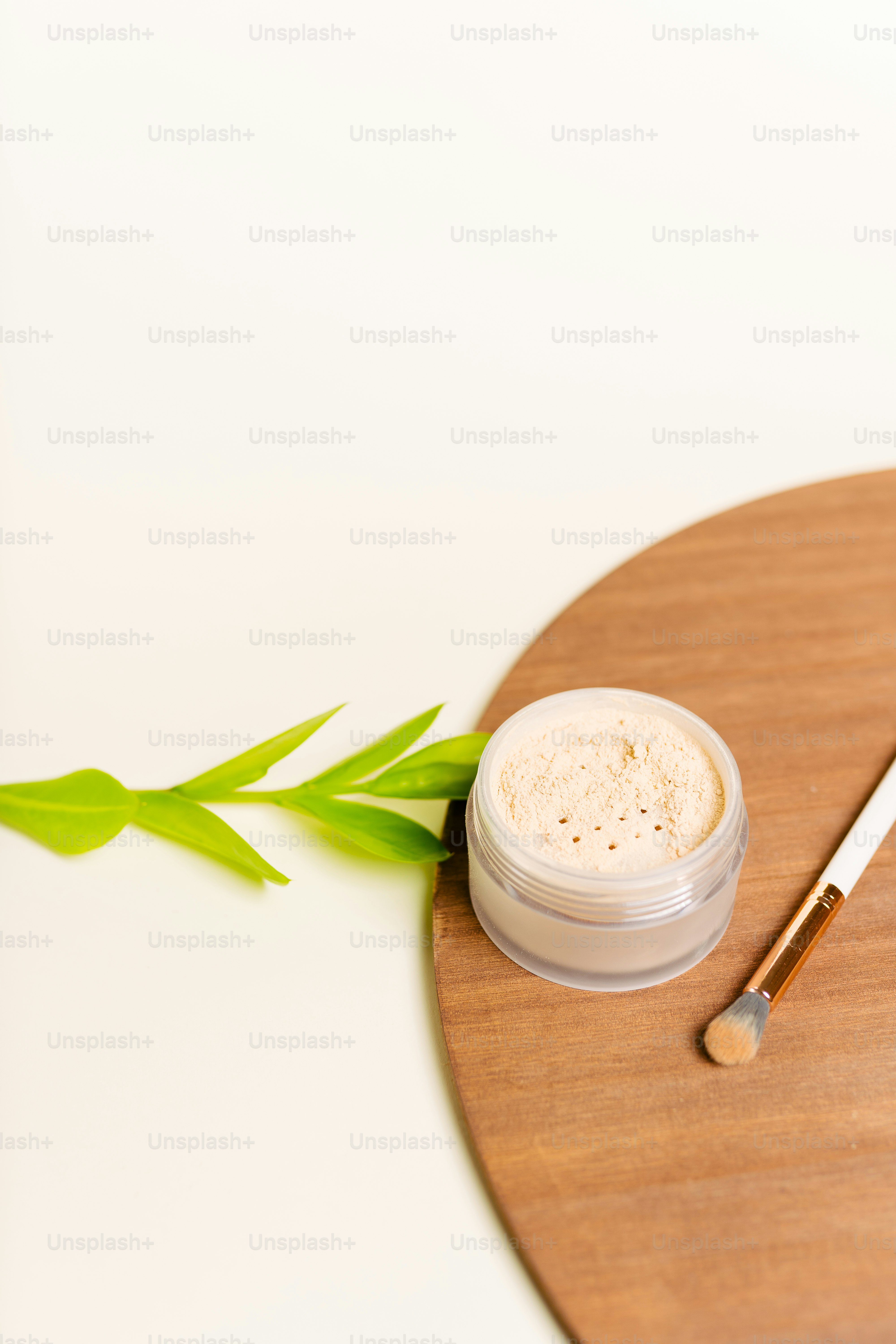 a wooden cutting board with a brush and a jar of cream on it