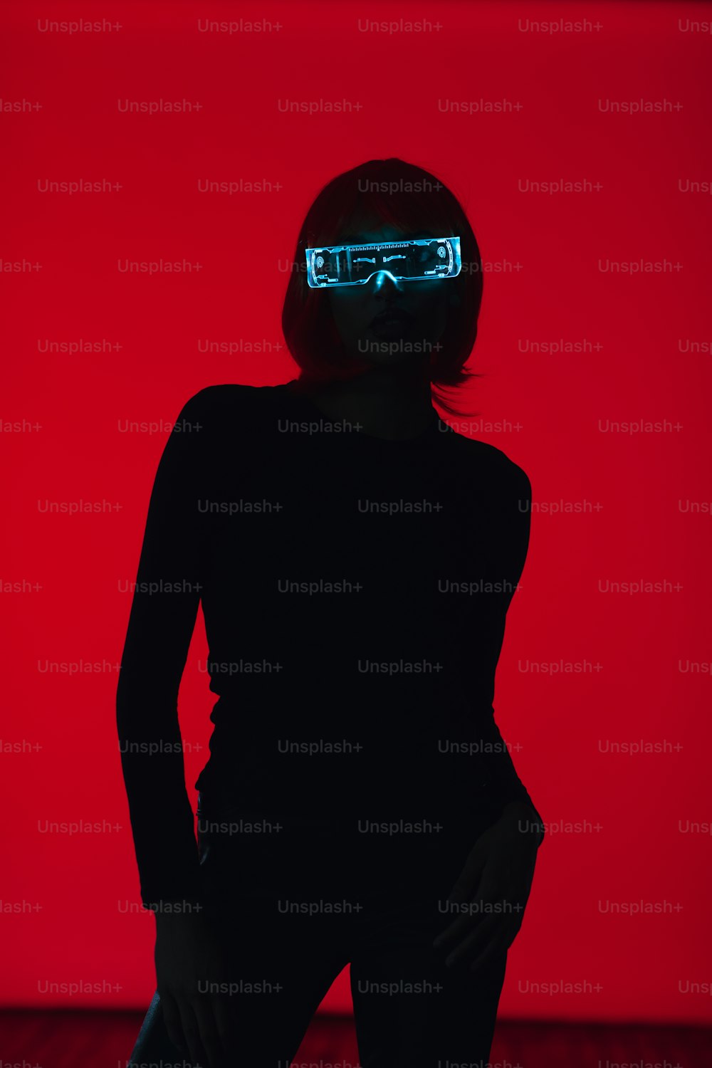a woman in a dark room with a neon mask