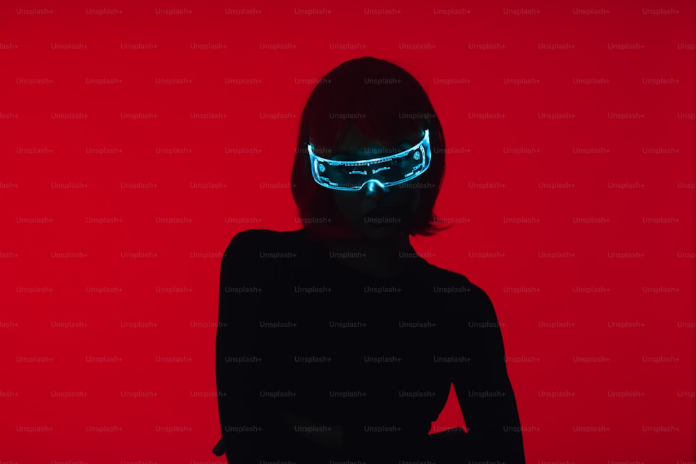 a woman in a black dress with a neon mask on