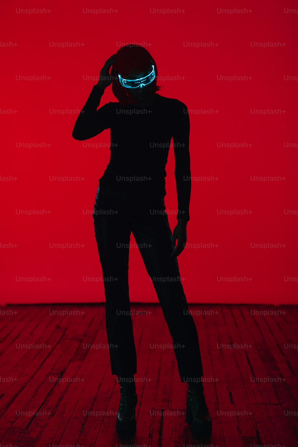 a woman in a dark room with a red background