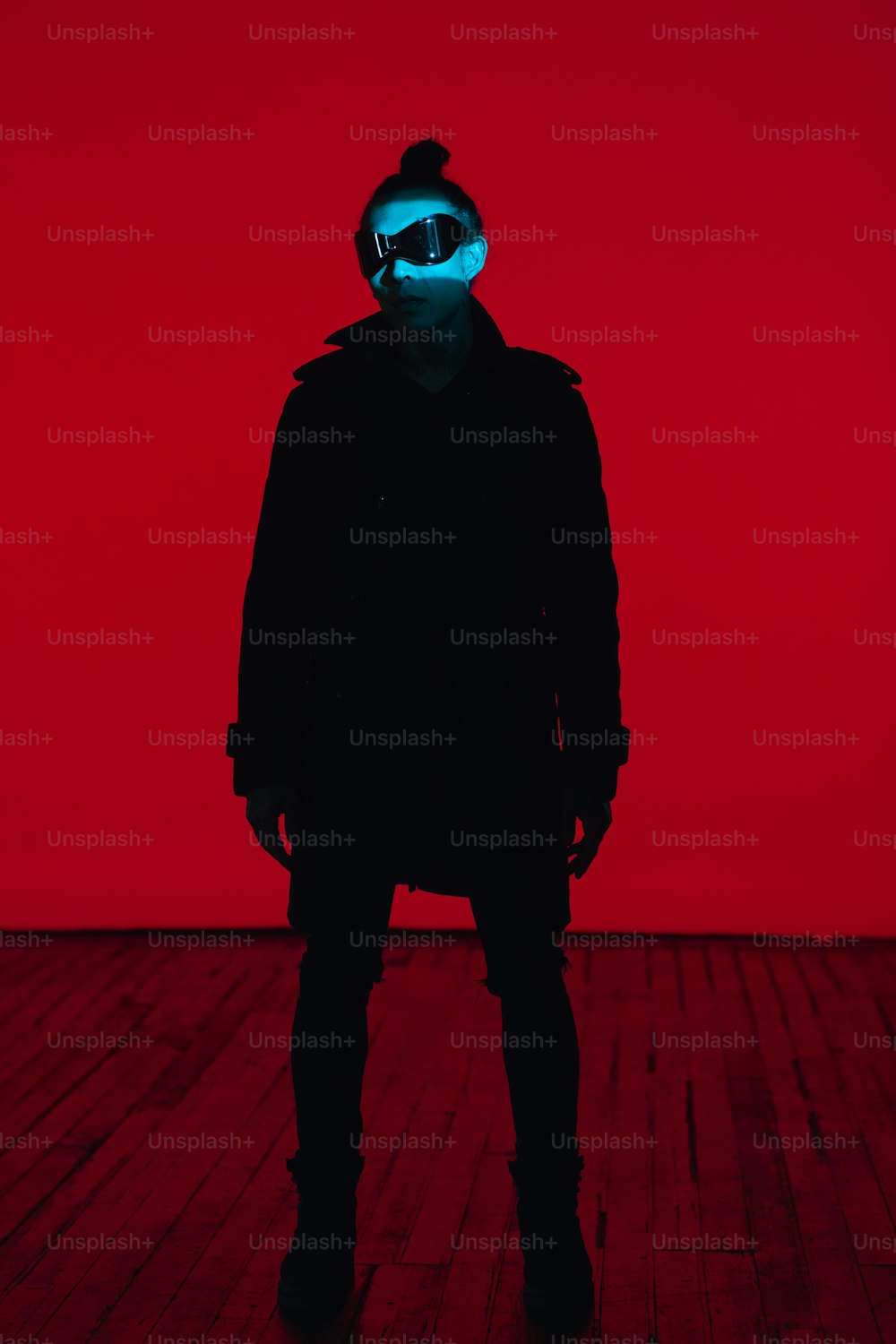 a man in a black coat with a blue light on his face