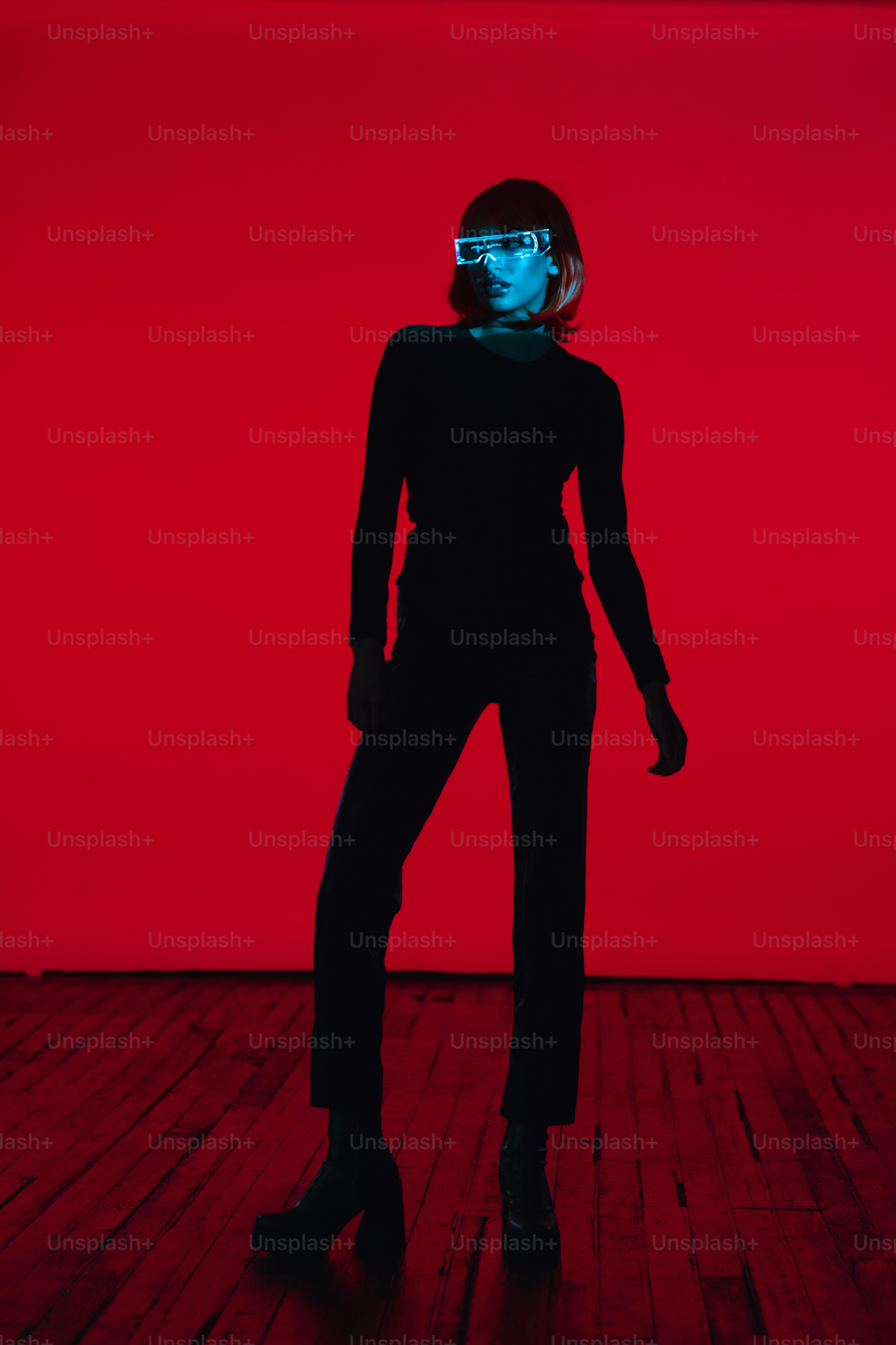 A woman standing in front of a red wall photo – Abstract Image on Unsplash
