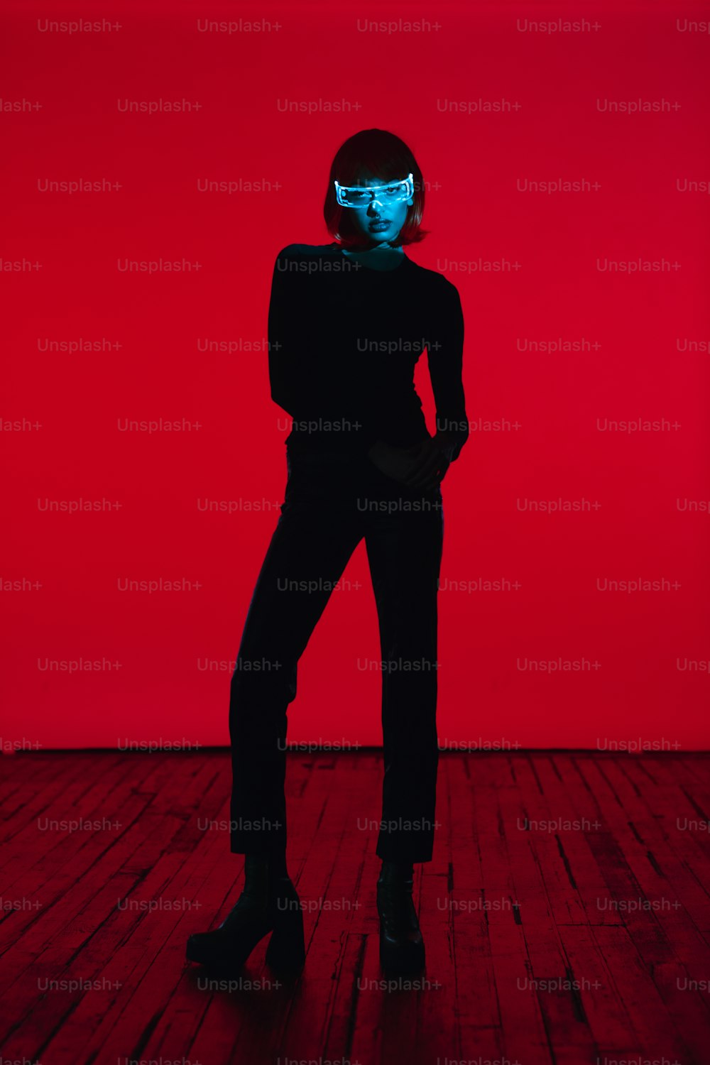 a woman standing in a room with a red background