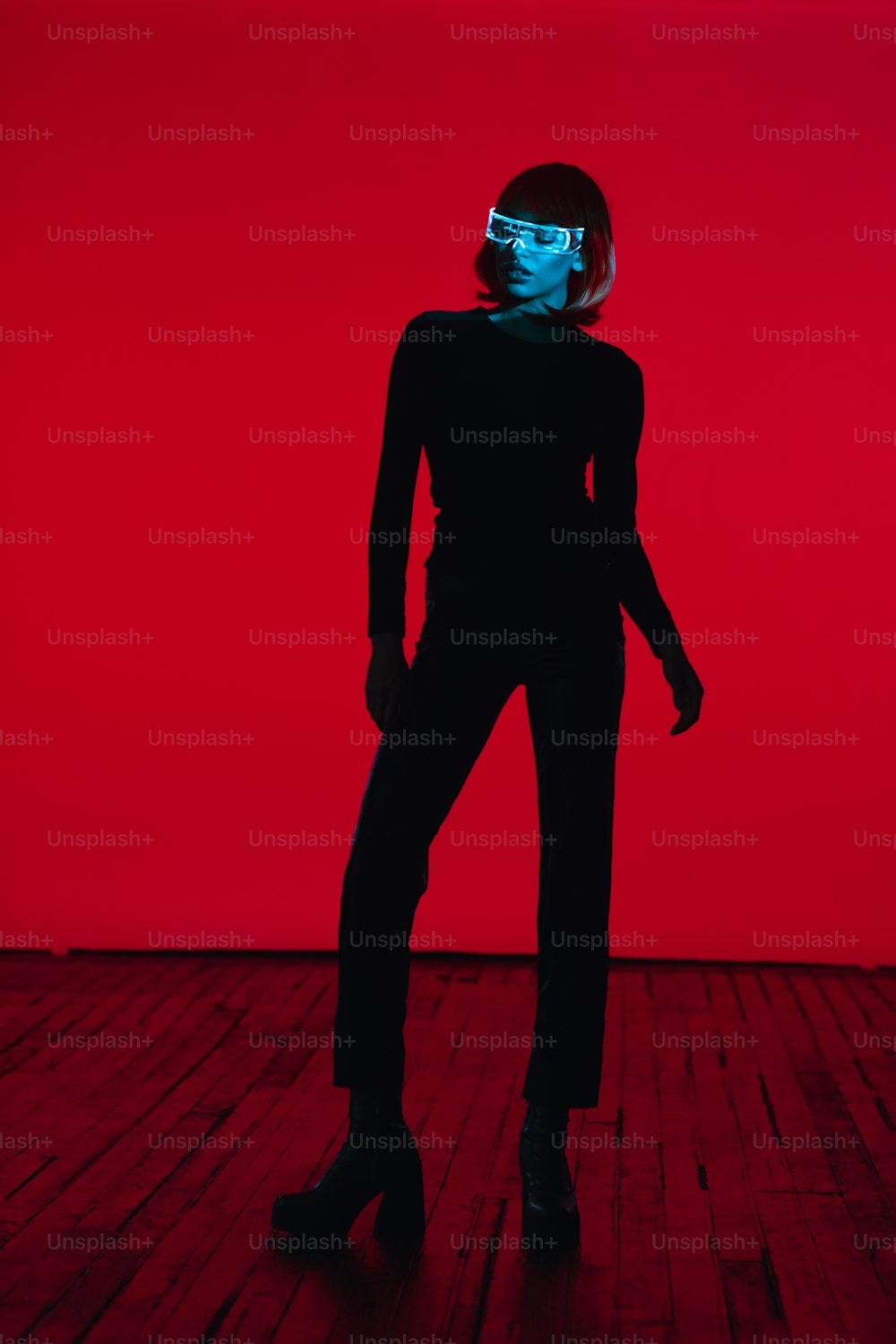 a woman in a black suit with a blue light on her face