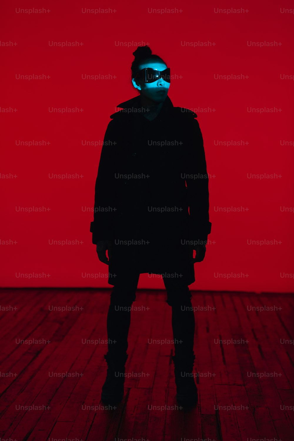 a person in a dark room with a red background