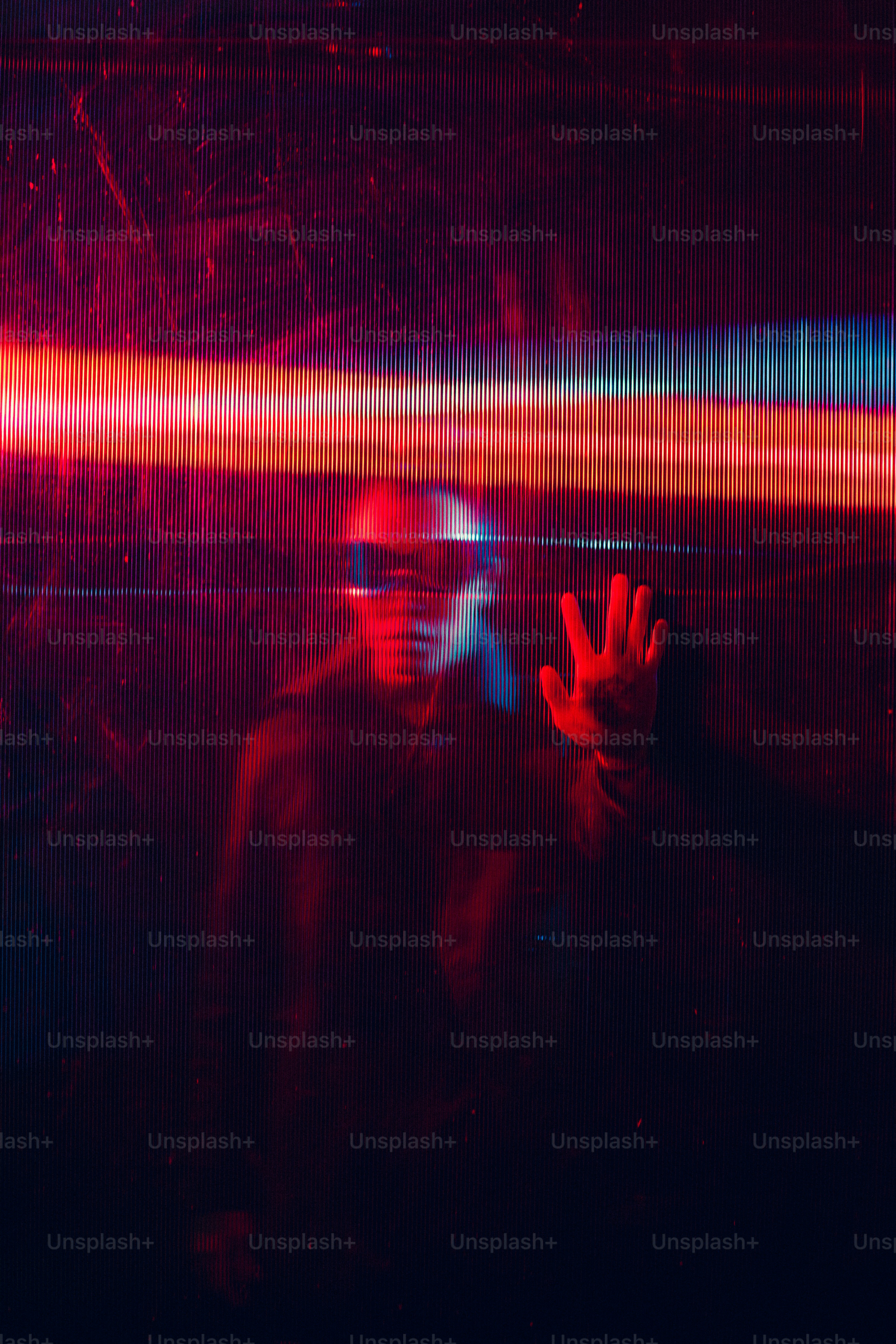 a man in a dark room holding his hand up