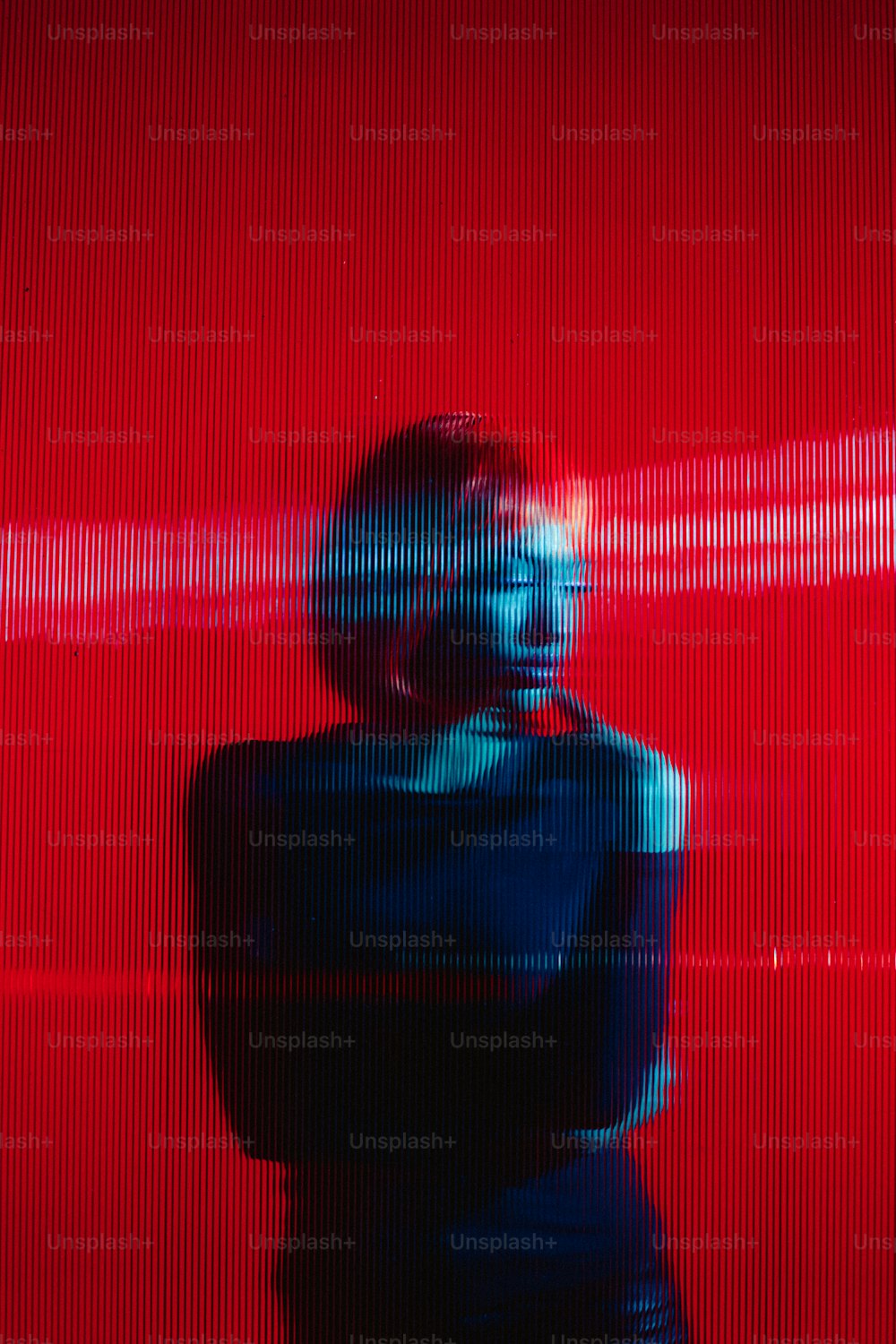 Una mujer parada frente a una pared roja