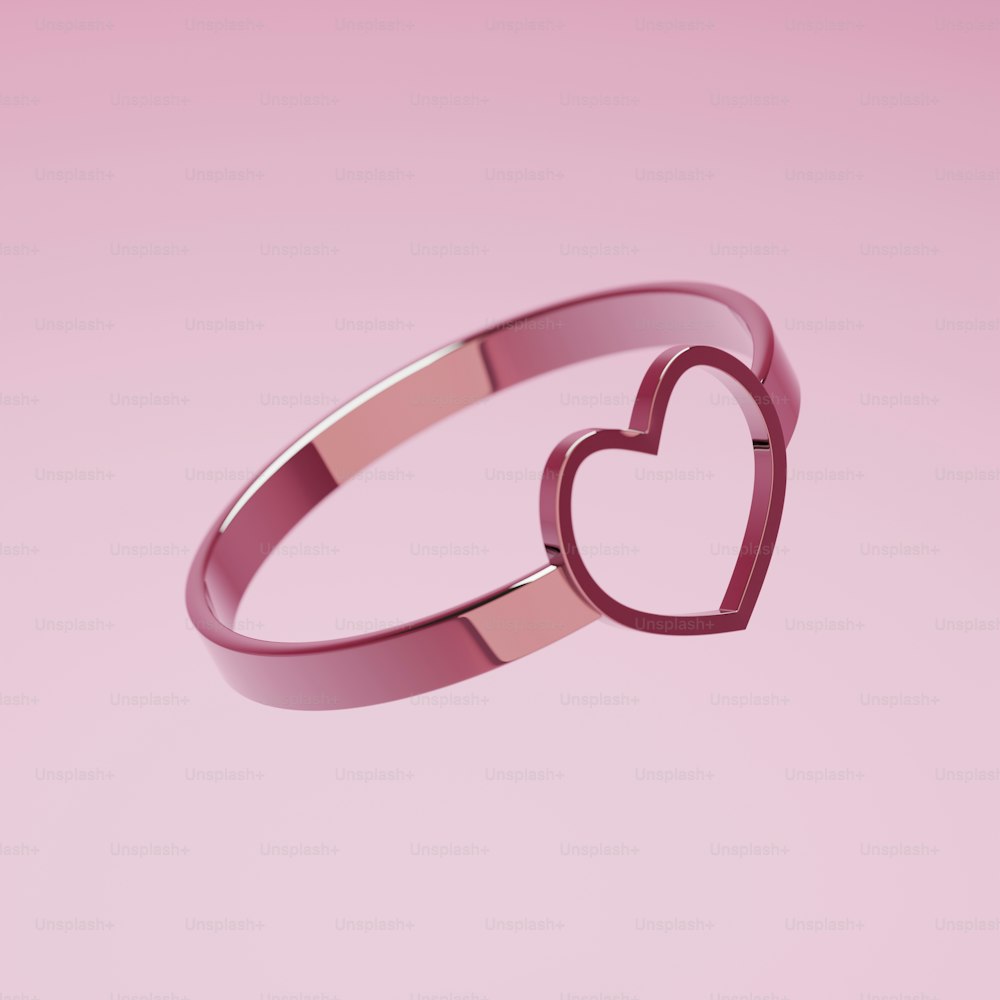 Ein rosa herzförmiger Ring auf rosa Hintergrund