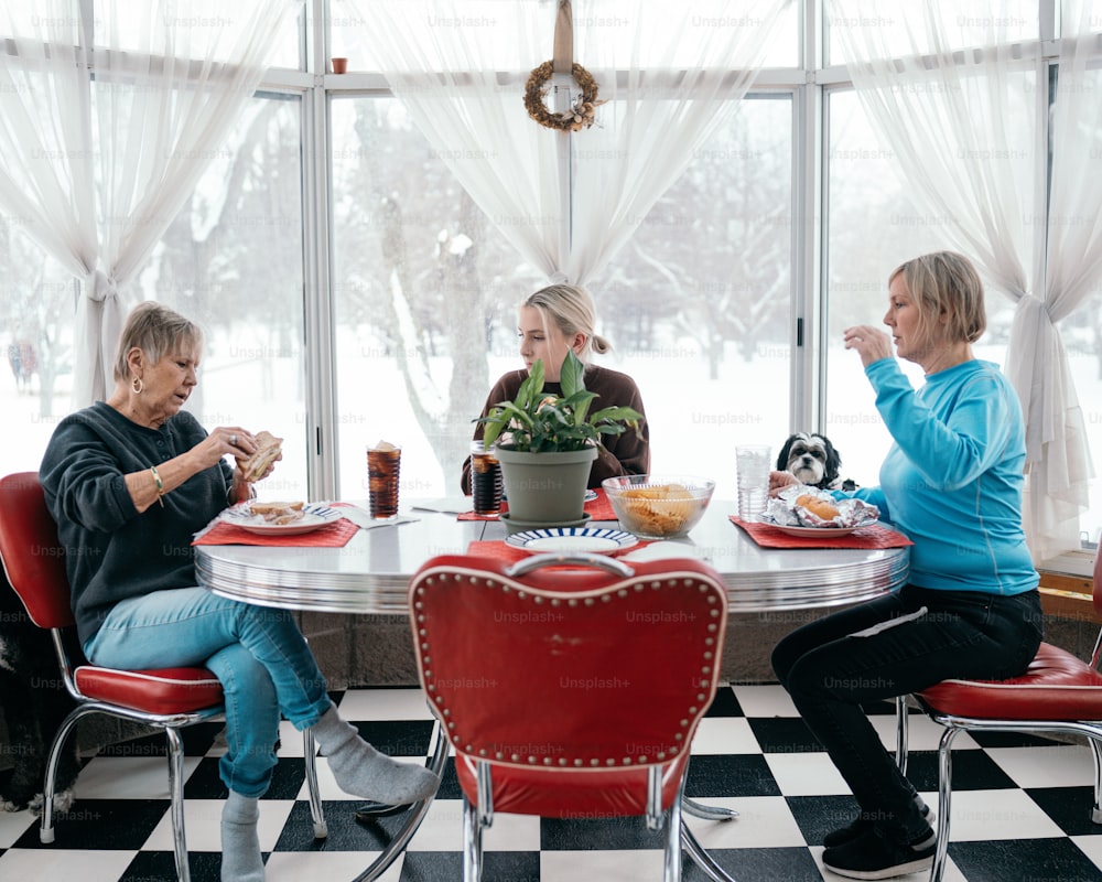 Eine Gruppe von Frauen, die um einen Tisch sitzen und Essen essen
