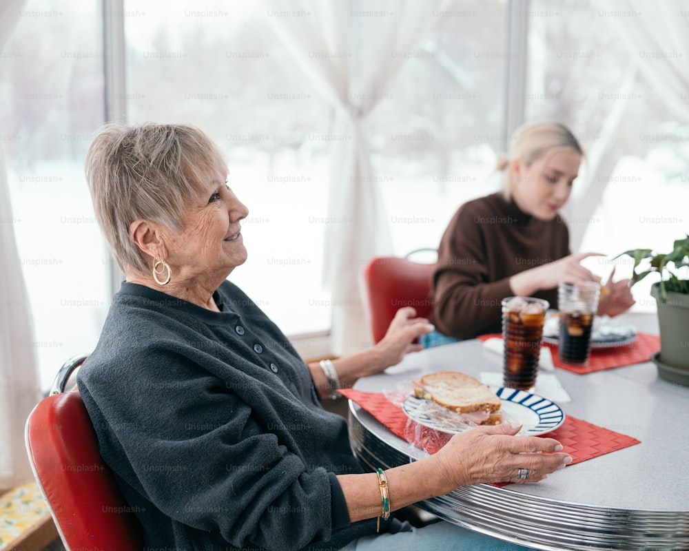 a woman sitting at a table with a plate of food