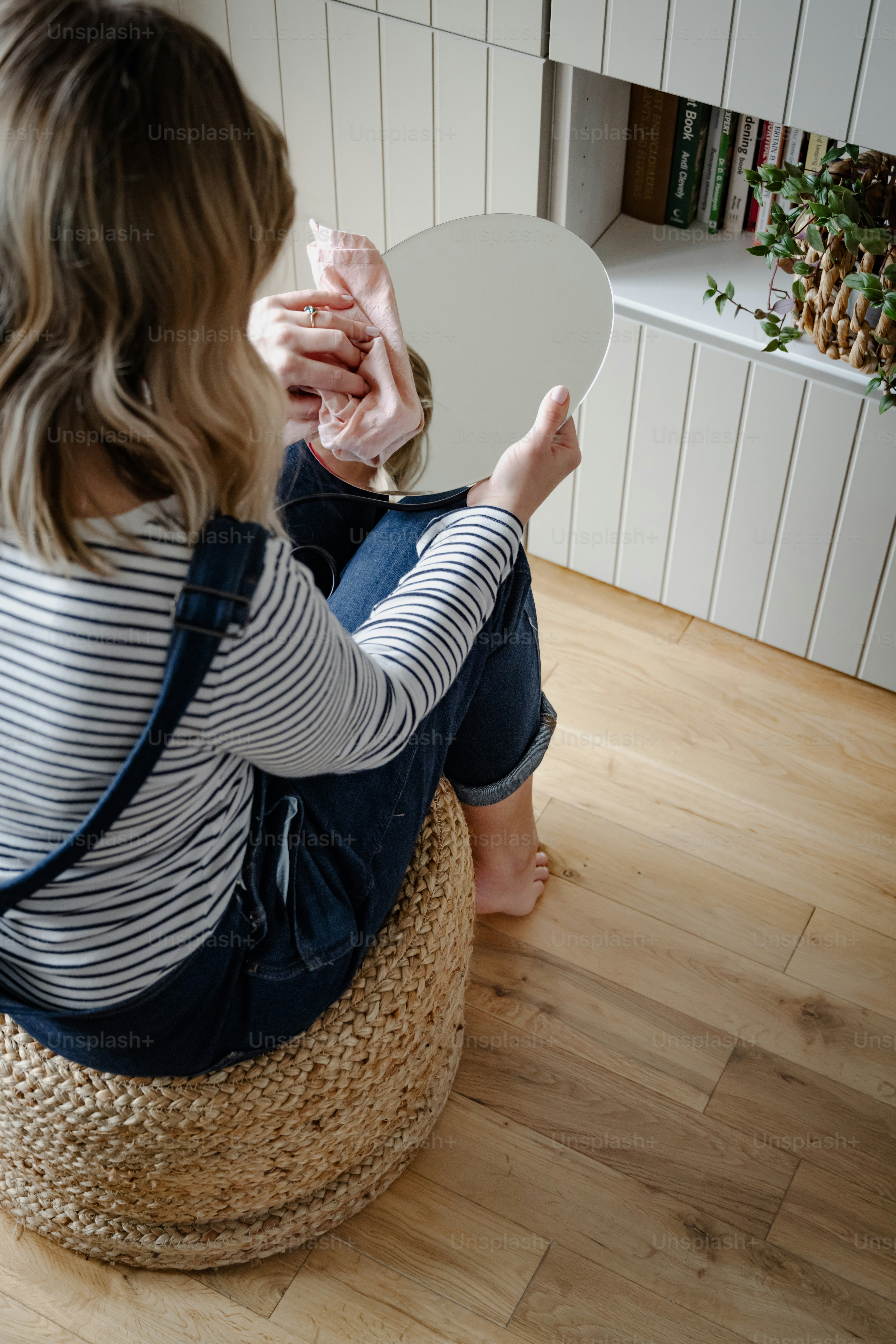 a woman sitting on the floor holding a mirror