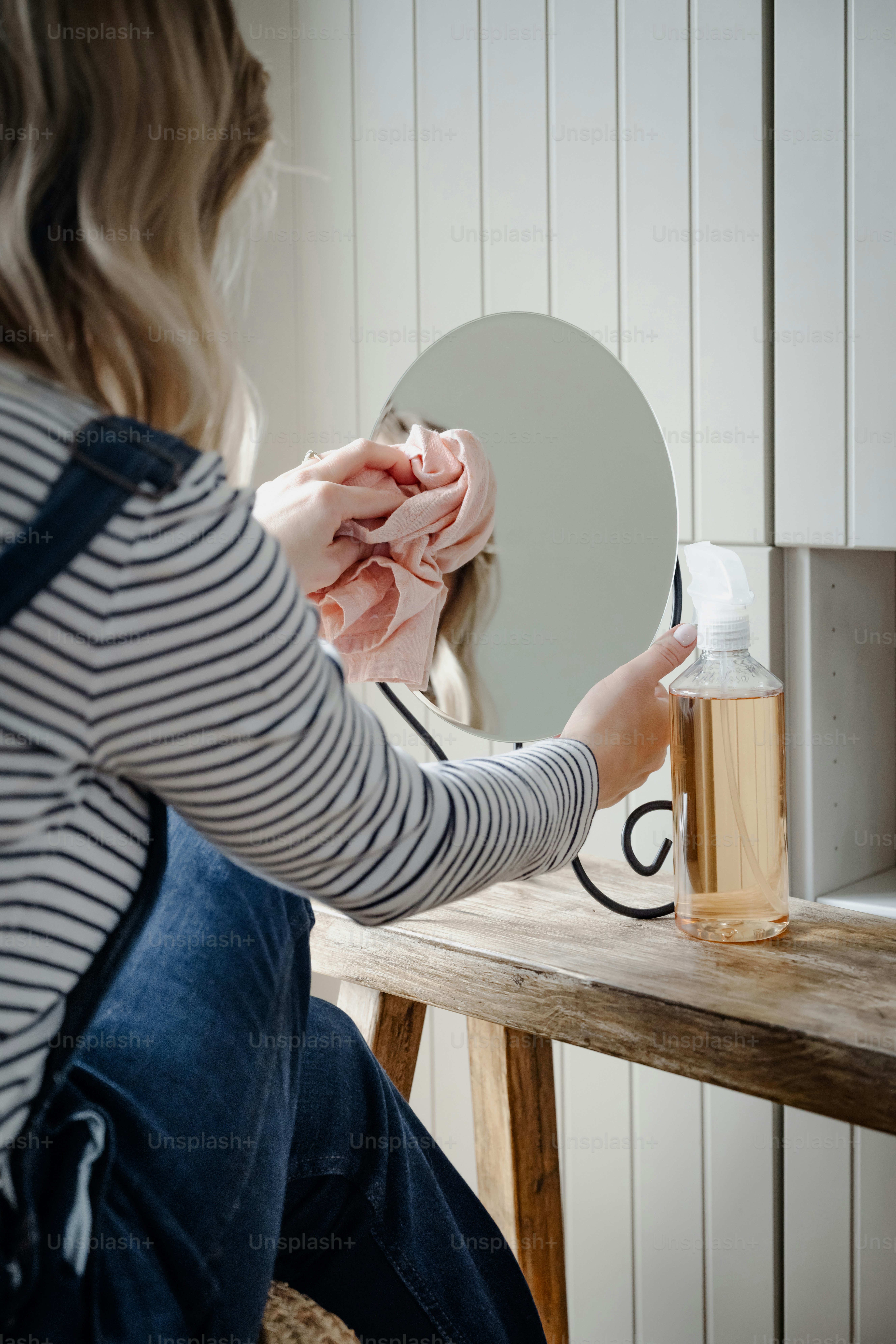 a woman sitting at a table with a bottle of soap