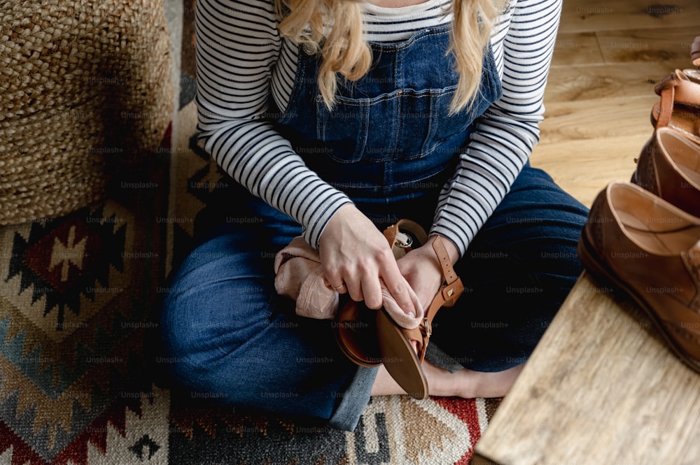 a woman sitting on a couch holding a pair of shoes