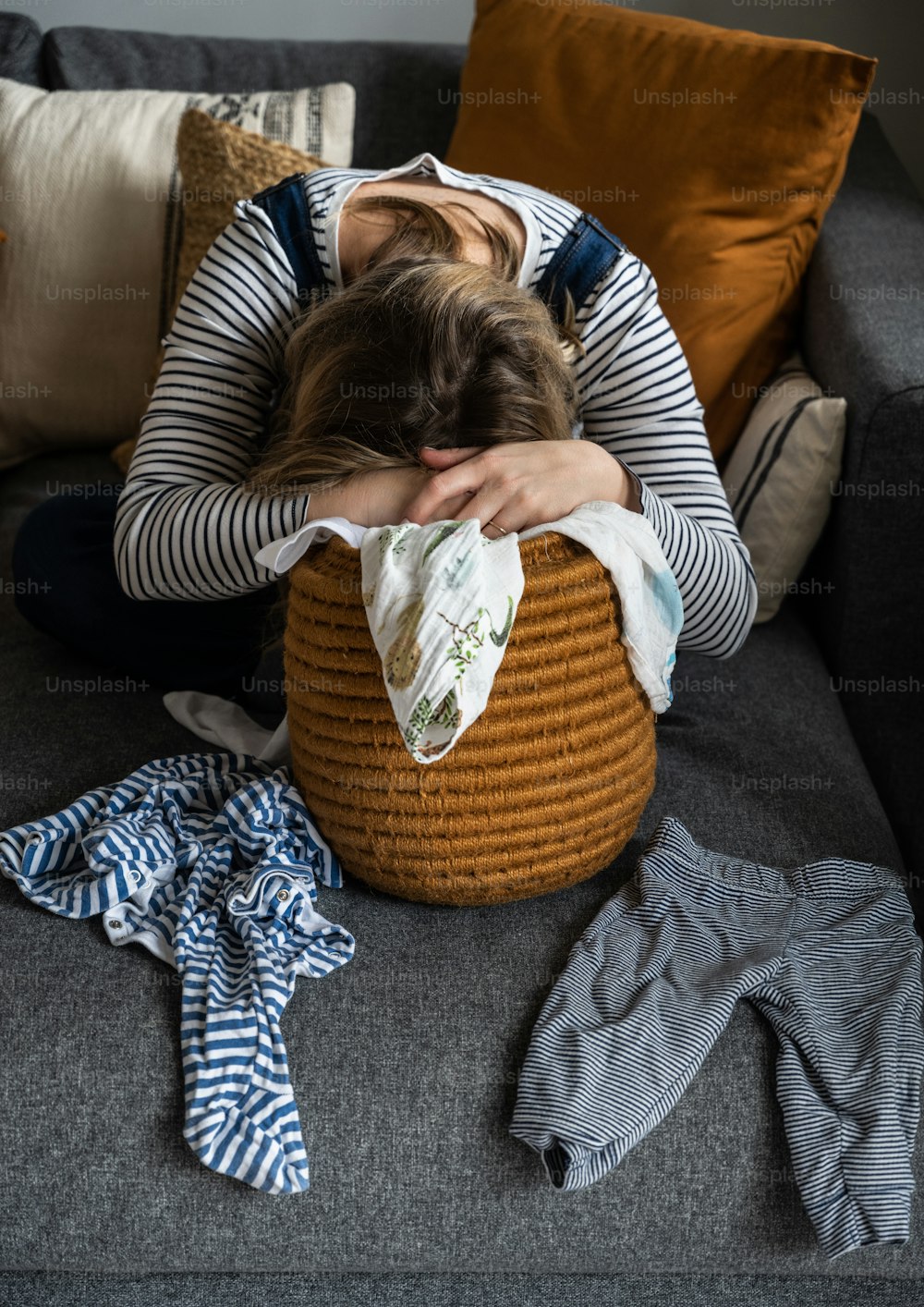 a woman laying on a couch with her head in a basket