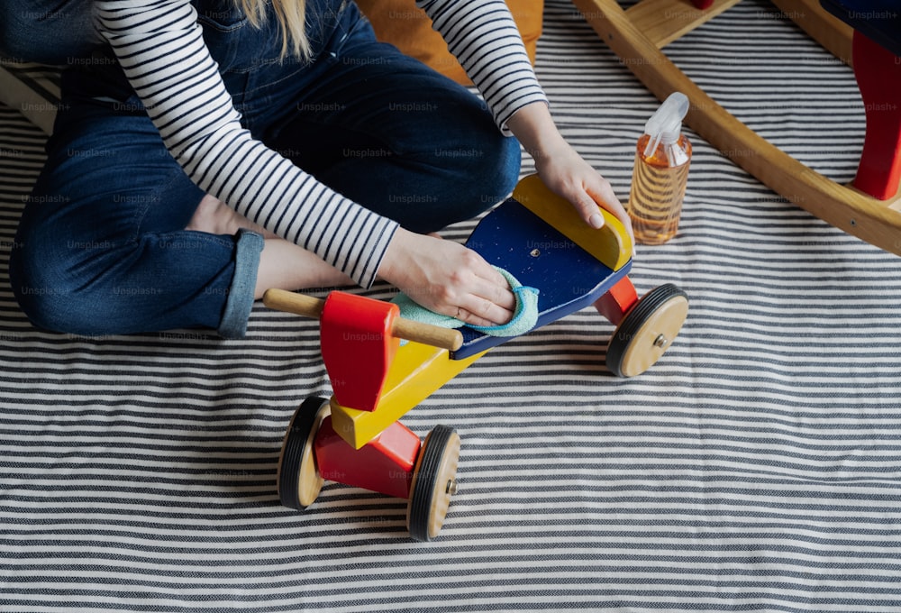 床に座っておもちゃのスケートボードで遊ぶ若い女の子