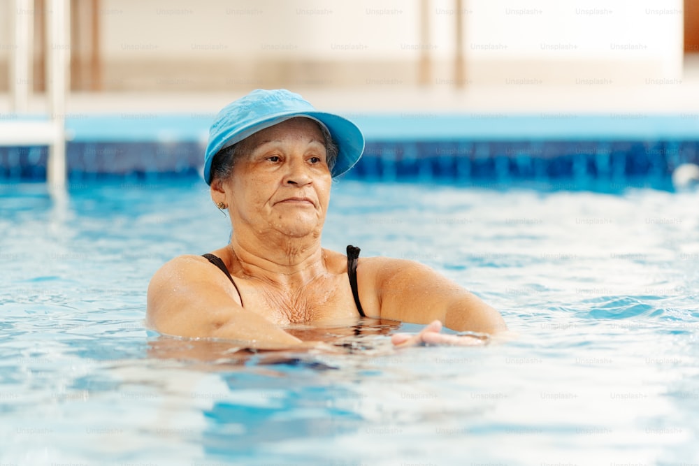 Une femme dans une piscine portant un chapeau bleu