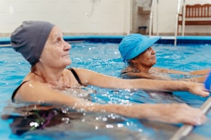 a woman in a pool with a blue hat on
