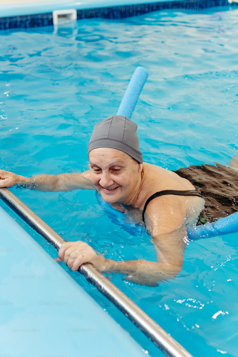 uma mulher nadando em uma piscina vestindo uma touca de natação