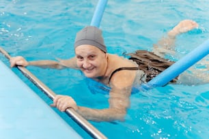 a woman swimming in a pool wearing a hat