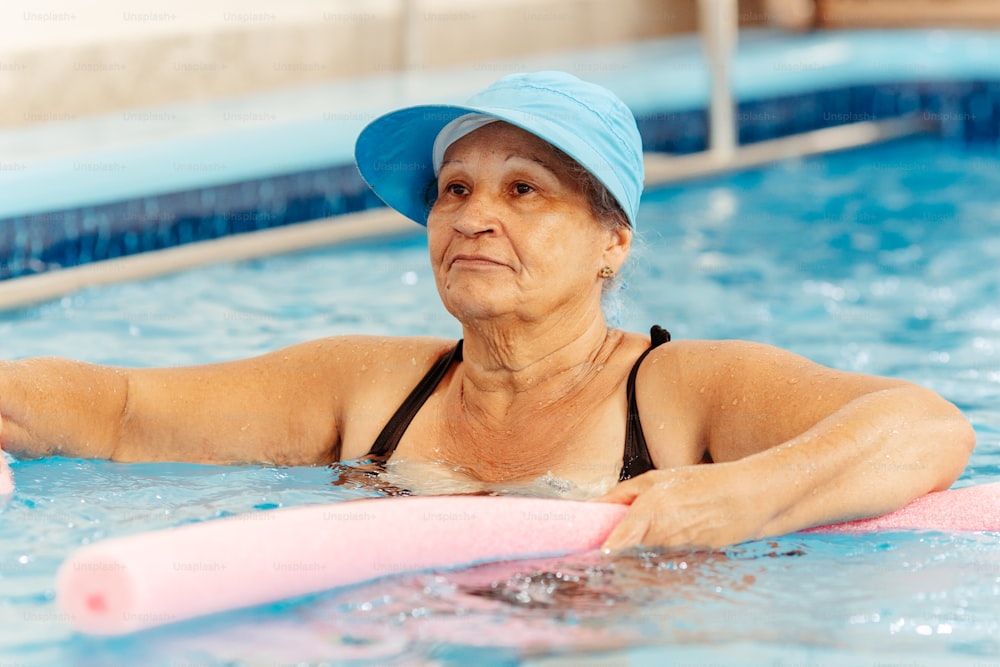 Una mujer con sombrero azul está en una piscina