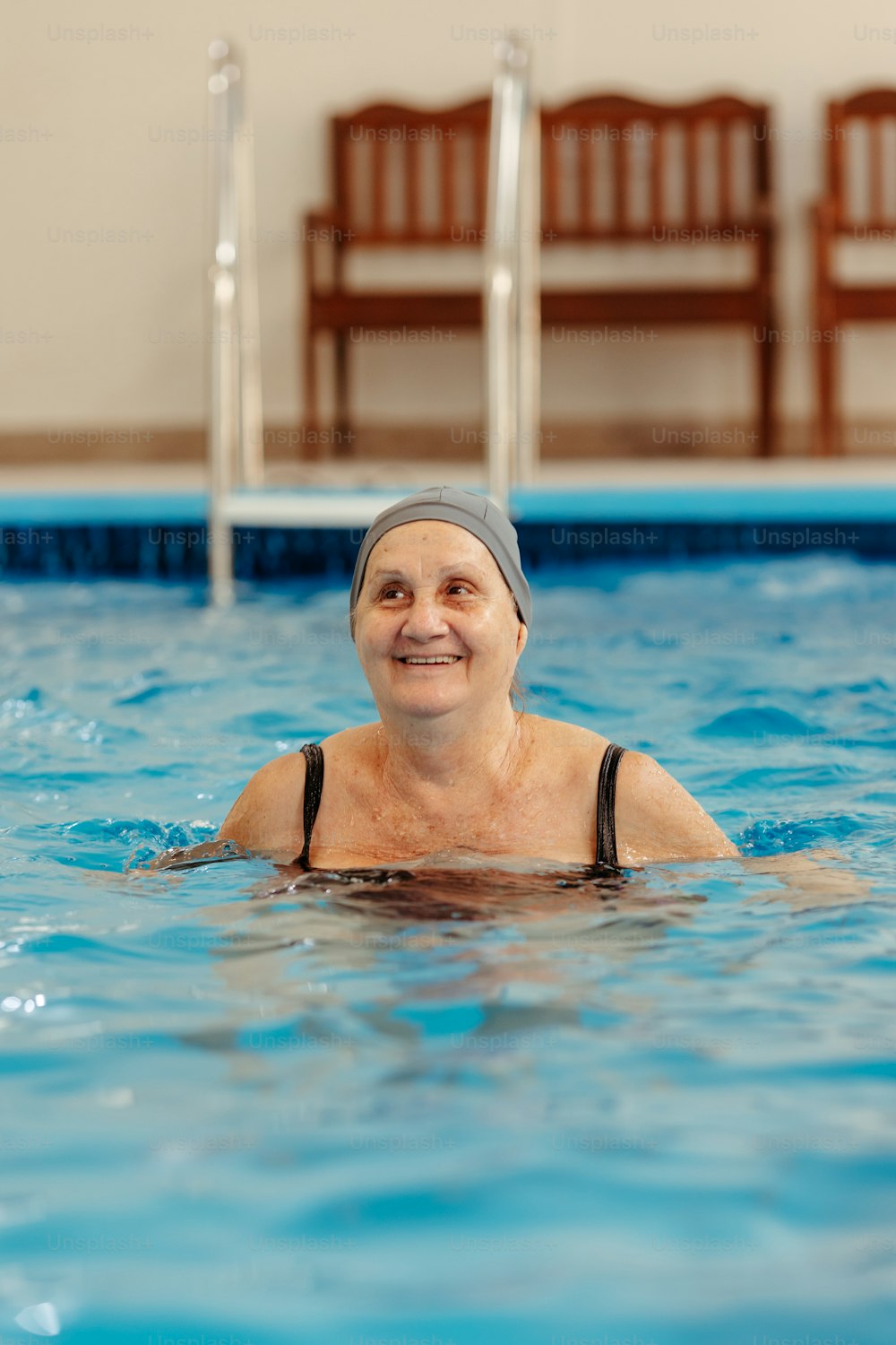 a woman in a swimming pool with a towel on her head