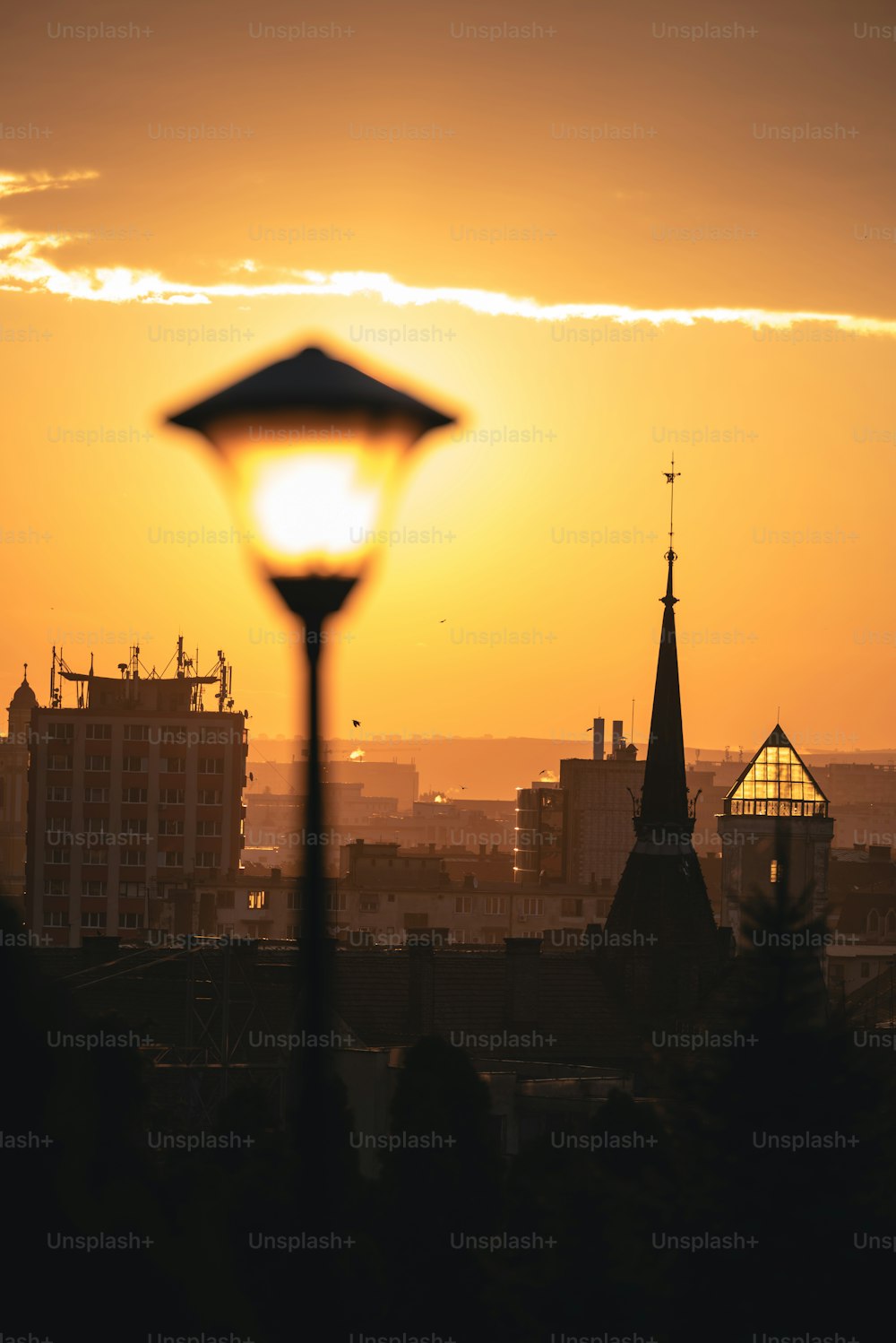 a street light in front of a sunset